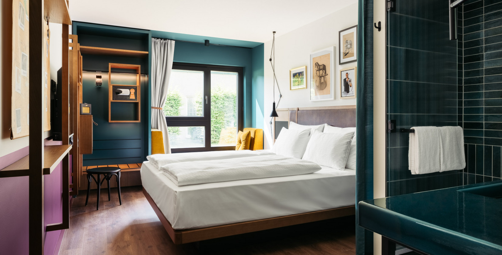 Offener Schrank, Sitzbank und Doppelbett im Hotel Schani UNO City Wien